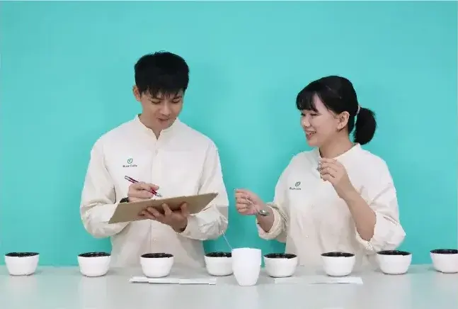 雙人於杯測桌前討論風味並記錄杯測結果